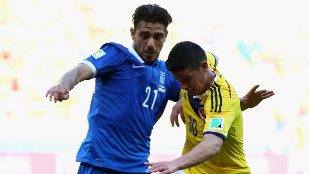 Kostas Katsouranis battles for the ball against James Rodriguez of Colombia during the 2014 FIFA World Cup Brazil