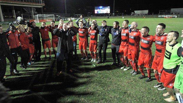 Redlands players and officials singing the team song on the pitch after the win over Adelaide United.