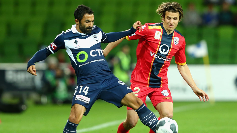 Victory midfielder Fahid Ben Khalfallah challenges for the ball with Reds defender Michael Marrone.